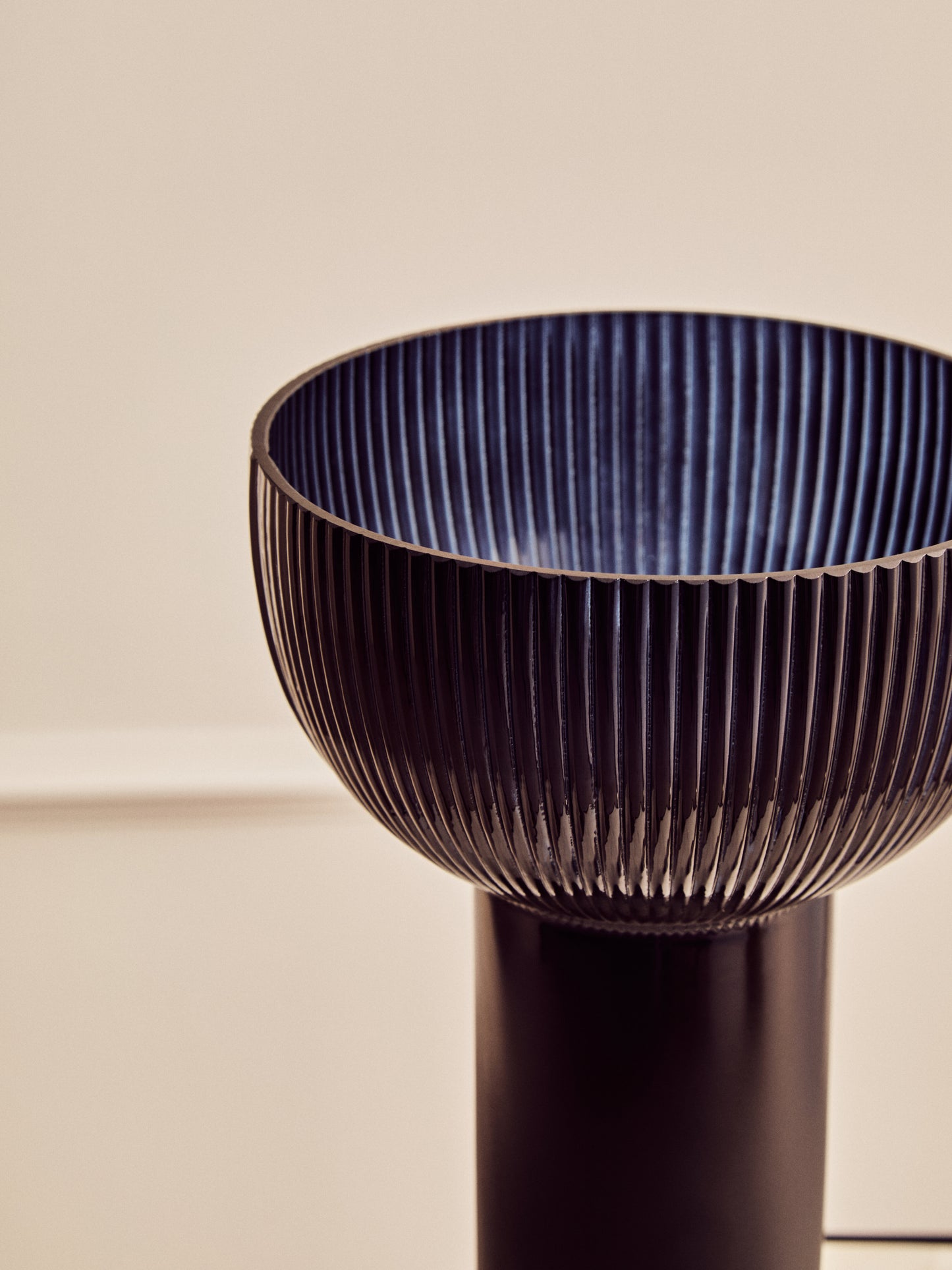 Decorative vase with ribbed design on a beige background