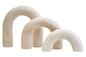 Set of three beige arch-shaped sculptures on a white background