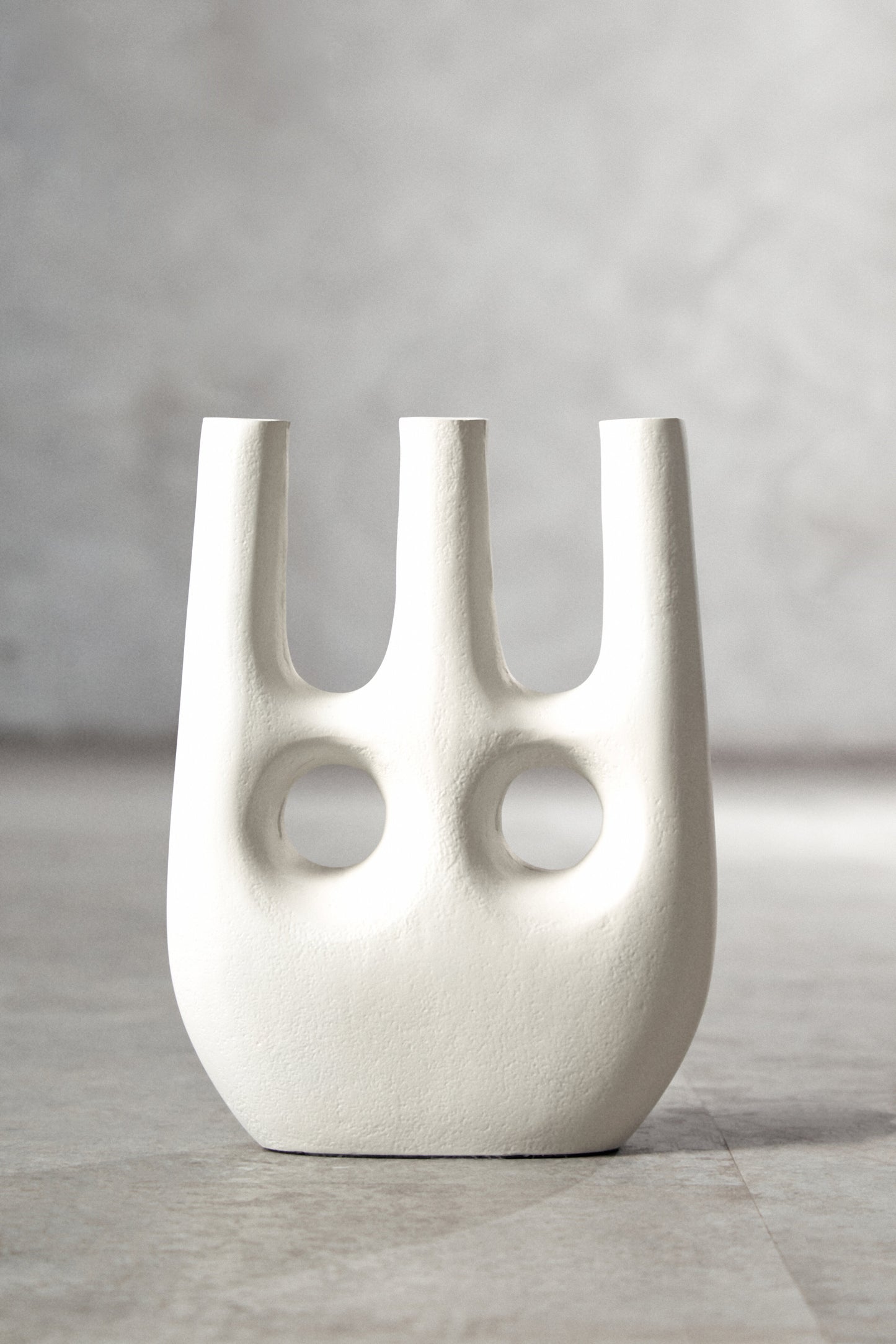 White abstract vase on a gray surface with a neutral background