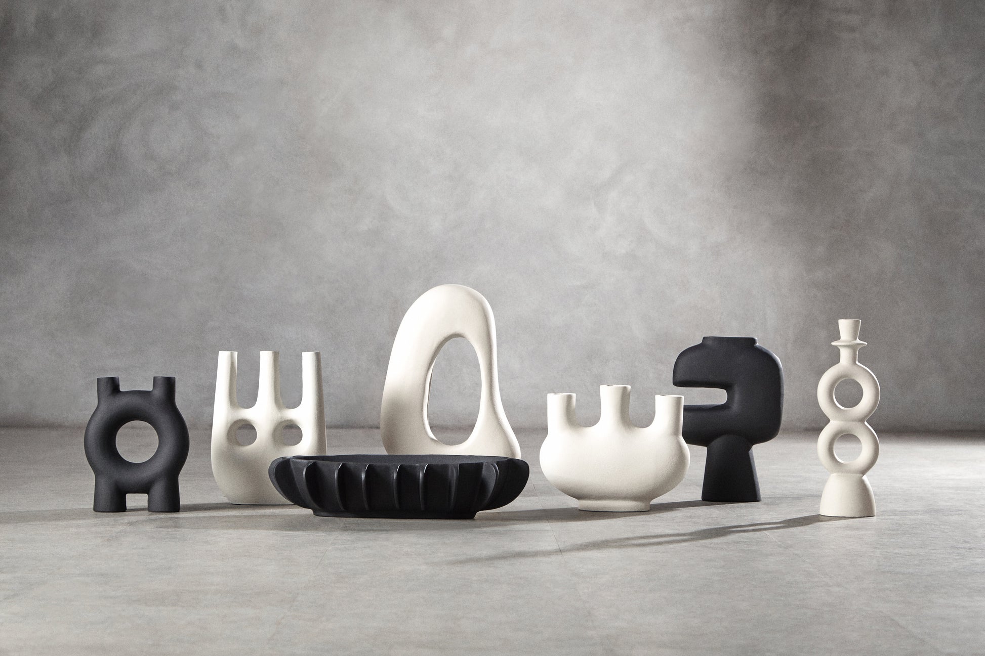 Set of abstract ceramic sculptures on a gray surface with a neutral background