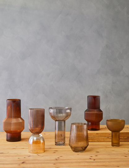 Set of glass vases on a wooden surface with a gray background