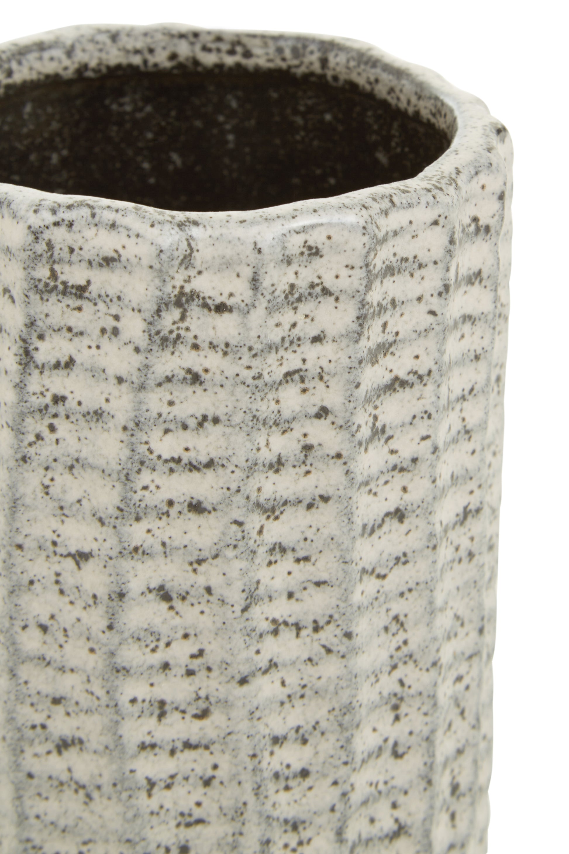 Close-up of a textured ceramic vase with a ribbed surface.