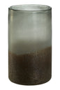 Tall cylindrical glass with gradient color from clear to brown on a white background