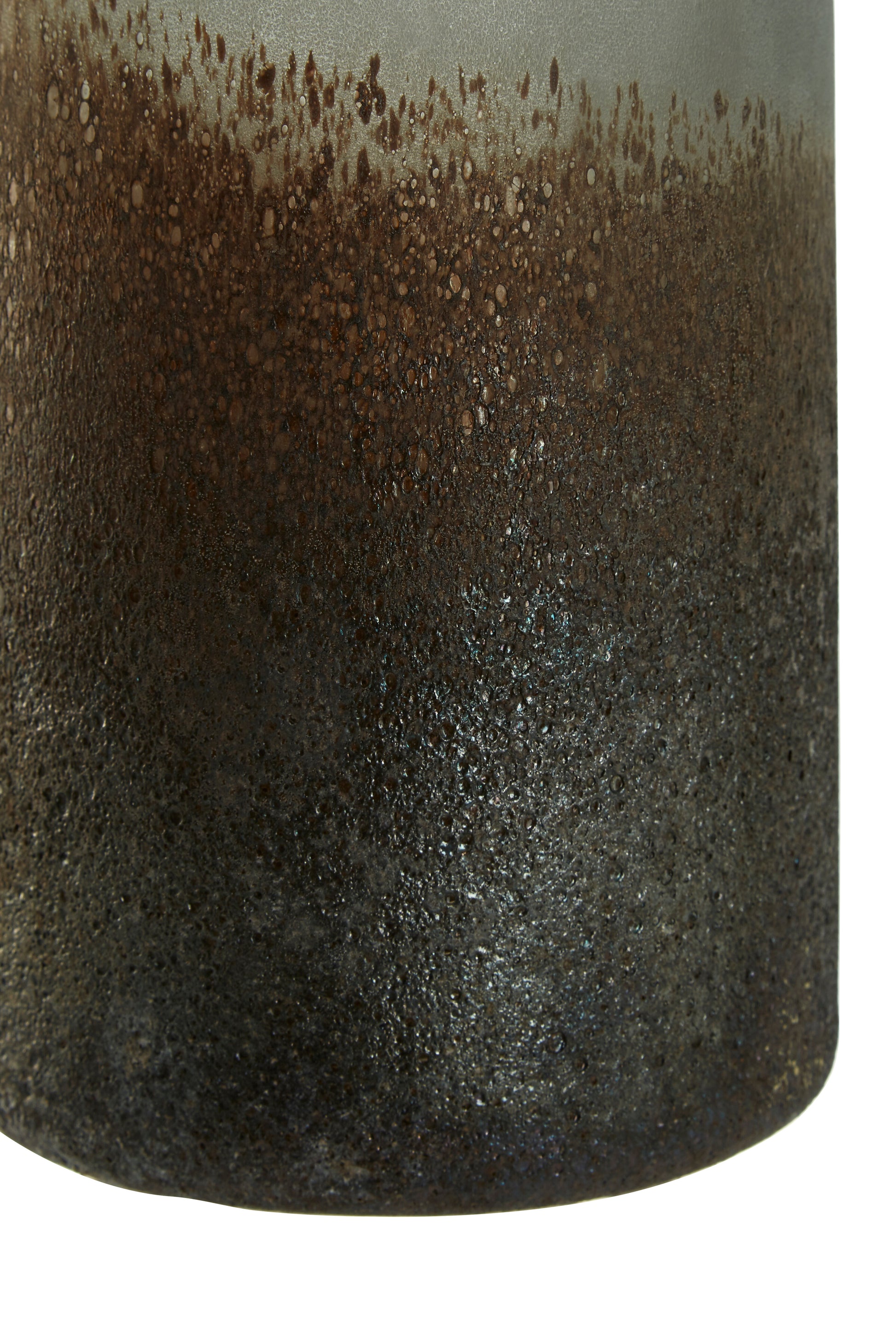 Close-up of a cylindrical ceramic vase with a textured surface and gradient color from brown to black.